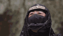a close up of a person wearing a black mask with studs on it
