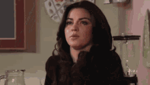 a woman with tears running down her face is sitting at a table