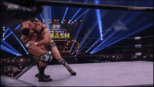 two wrestlers in a wrestling ring with a sign that says smash