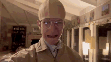 a man wearing a hat and glasses is standing in a living room