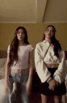 two girls are standing next to each other in a hotel room