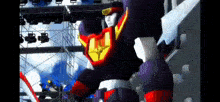 a giant robot is standing in front of a stage with a lot of lights .