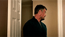a man with a beard is standing in a doorway .