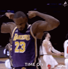 a basketball player with the number 23 on his jersey is flexing his muscles during a game .