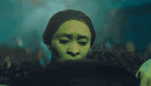 a woman with green hair is covering her face