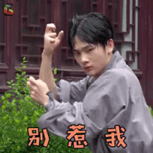a man in a kimono is making a karate pose with his hands in front of a building .