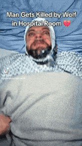 a man is laying in a hospital bed with a bandage on his head and mouth .
