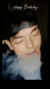 a man wearing a headband is smoking a cigarette with the words happy birthday written above him .