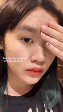 a close up of a woman covering her face with her hand with a sticker that says ' a ' on it