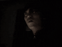 a black and white photo of a person 's face in the dark