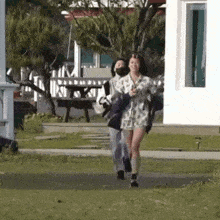 a man and a woman are walking down a sidewalk in front of a building .