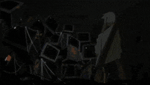 a bunch of televisions are stacked on top of each other in a room