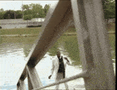 a man in a white jacket stands on a bridge overlooking a body of water