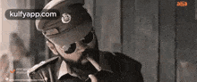 a police officer is smoking a cigar and wearing sunglasses .