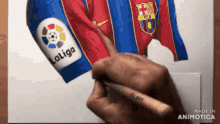 a person is drawing a soccer jersey with laliga on the sleeve