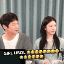 a man and a woman are sitting in front of a sign that says girl ijbol on it