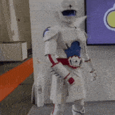 a man in a white and blue robot costume is holding a bat
