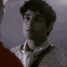 a man with a scarf around his neck is looking at another man