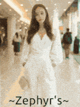 a woman in a white dress is walking down a hallway with the words zephyr 's written on the bottom