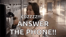 a woman is talking on a pay phone in a hallway and saying `` answer the phone '' .
