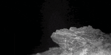a black and white photo of a large piece of ice floating in the air .