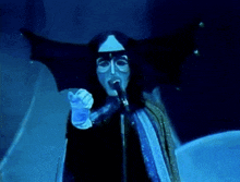 a person wearing a mask and gloves singing into a microphone
