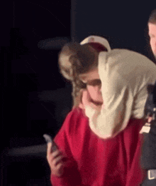 a man in a red sweater is hugging a woman in a white shirt .