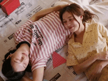 two people laying on a newspaper that says brooklyn on it