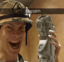 a man wearing a helmet and holding a phone with the word napalm written on the bottom