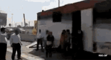 a group of people are standing in front of a building that says rbd gif on it