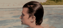 a man is swimming in a pool and his hair is visible