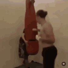 a man is standing next to a punching bag .