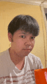 a man wearing a white shirt with red stripes looks at the camera