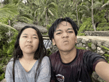 a man and a woman are posing for a picture and the man is wearing a shirt that says ' hawaii '