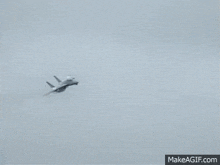 a fighter jet is flying through the air with smoke coming out of its tail .