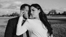 a black and white photo of a bride and groom kissing