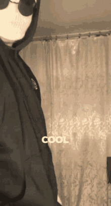 a person wearing a mask and a hoodie with the word cool on it