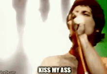 a man is singing into a microphone and says kiss my ass