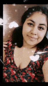 a woman is smiling and taking a selfie with hearts around her neck .