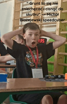 a boy is sitting at a desk with his hands on his head and a clock that says 135