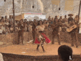 a woman in a red skirt is dancing in front of a group of men playing guitars