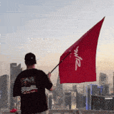 a man in a black shirt holds a red flag that says powr