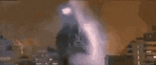 a very tall building is being destroyed by a very large explosion .