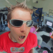 a man wearing sunglasses and a red shirt that says ' spongebob squarepants ' on it