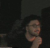 a man wearing glasses and headphones is giving the thumbs up
