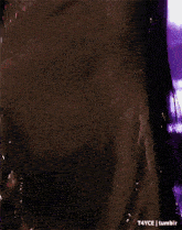 a close up of a person 's torso in a black dress with a purple background .