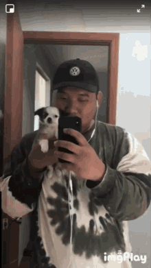 a man taking a picture of himself with a small dog