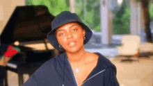 a woman wearing a bucket hat and a necklace with a cross on it
