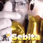 a man wearing glasses and headphones is pointing at something with the word sebita below him