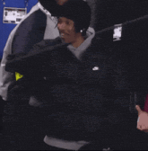 a man wearing a black nike jacket and a black beanie